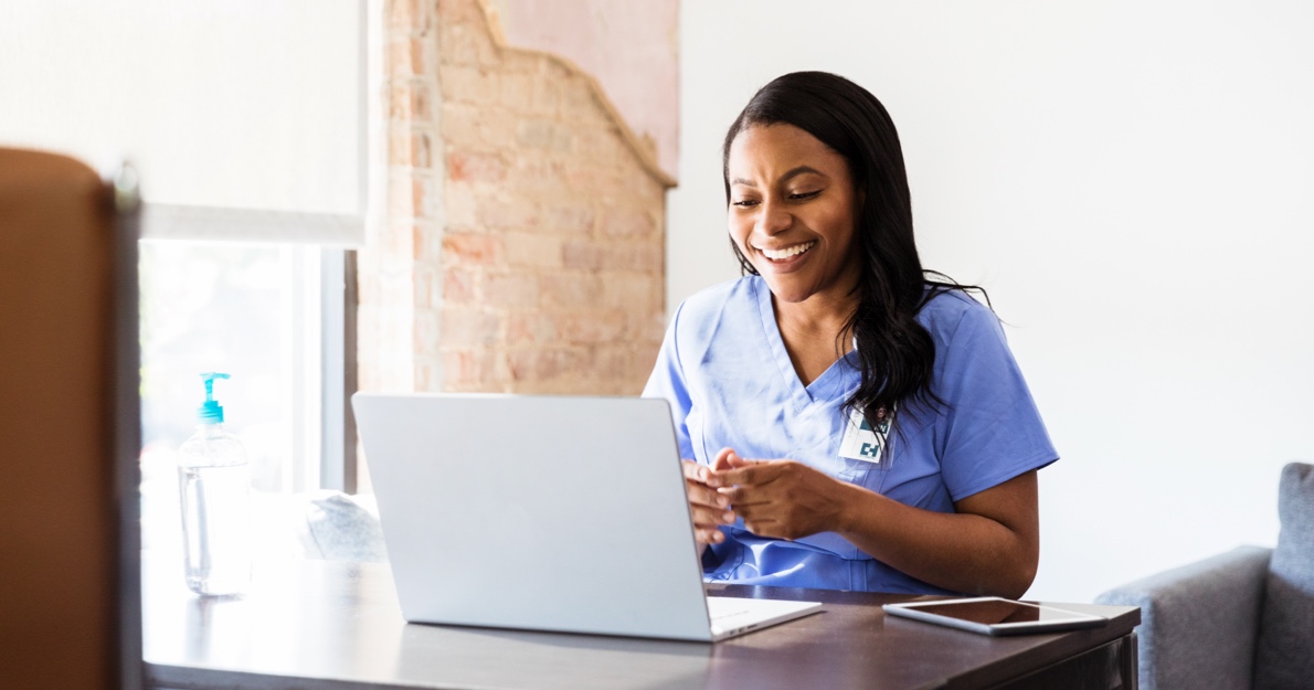 Young female medical professional looking at computer - HealthStream Learning and Performance